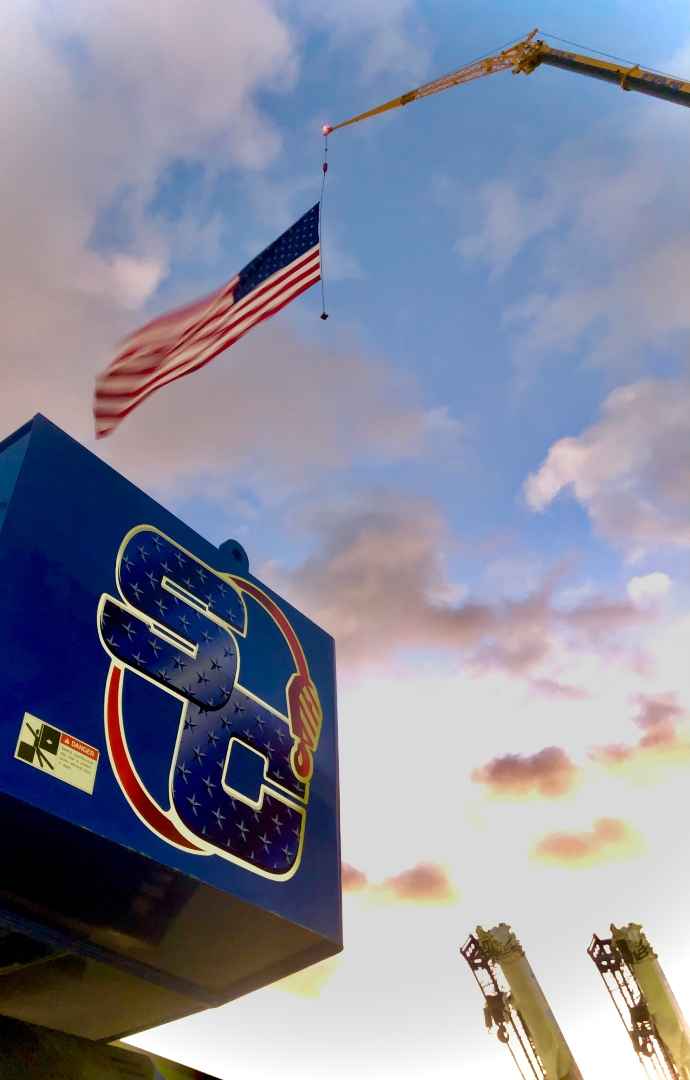 National Hire a Veteran Day Sterling Crane - American Flag hanging from a crane over Sterling Crane logo