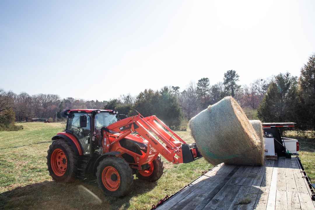 KIOTI Tractor lifting a haybale